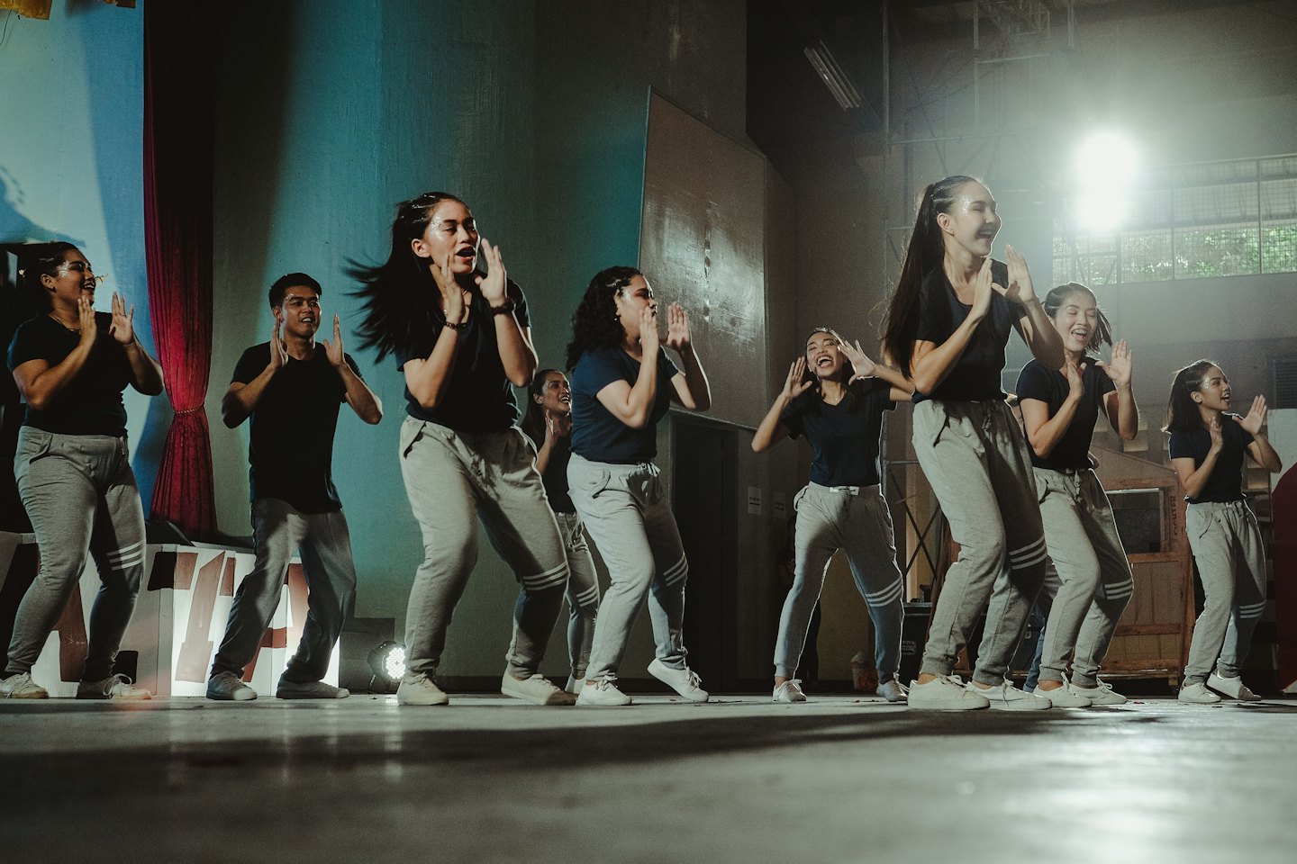 Young dancers in matching outfits performing energetically on a stage.