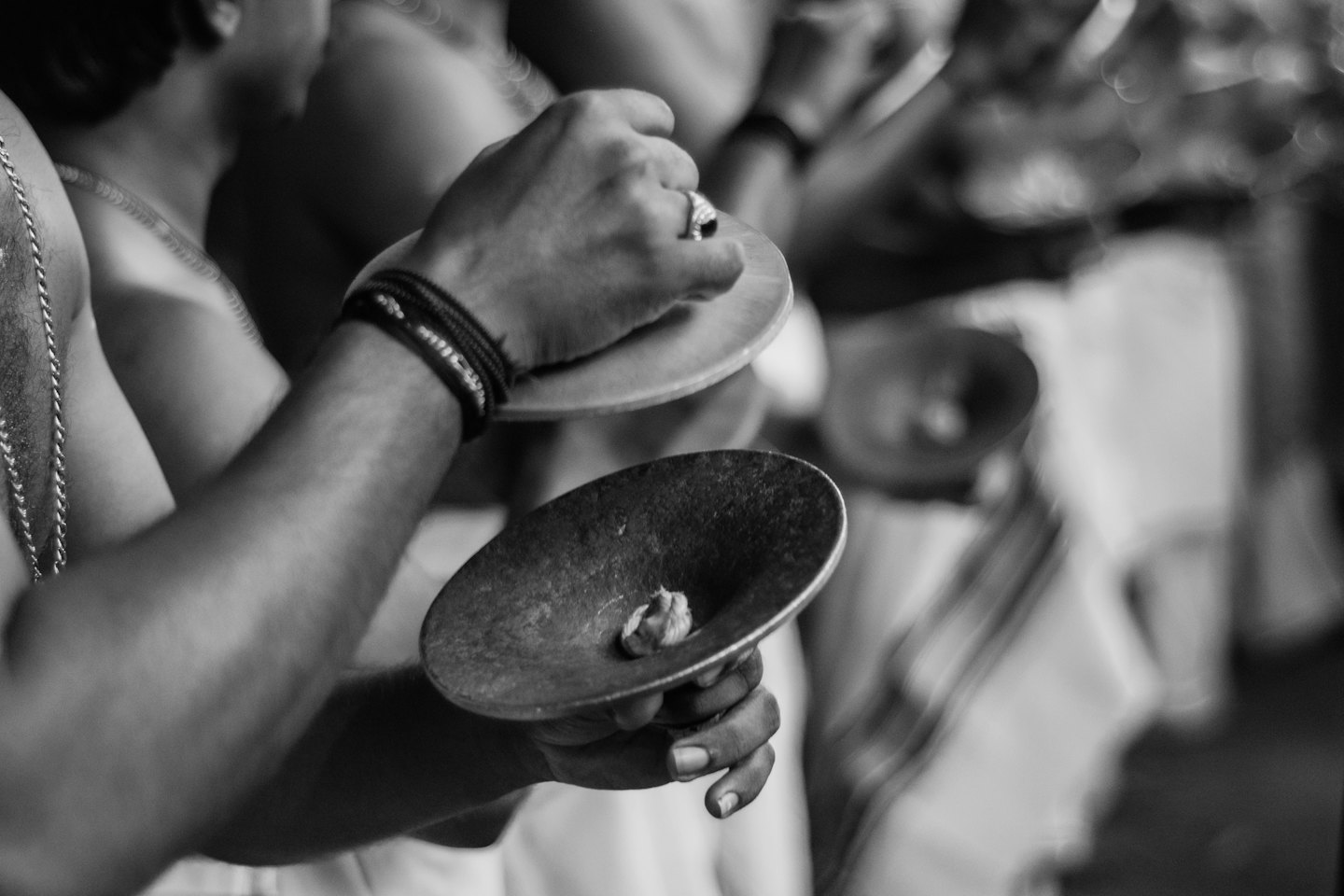 Two hands hold small brass cymbals during a performance.